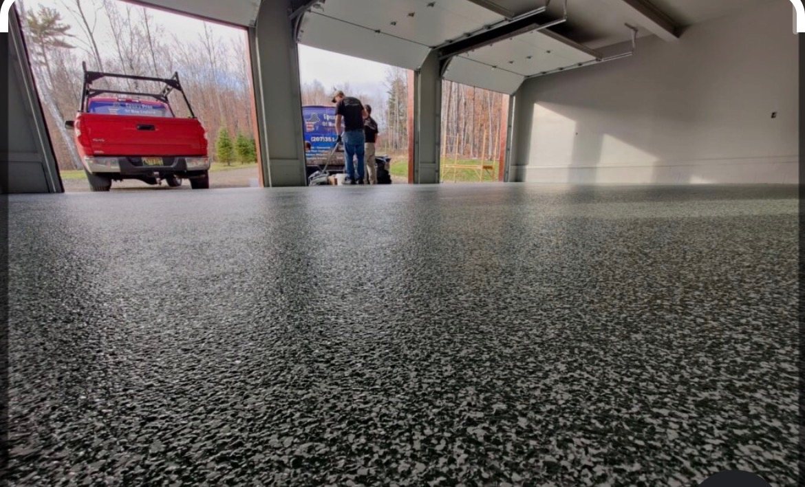 Grey and black flake epoxy garage floor with a truck outside