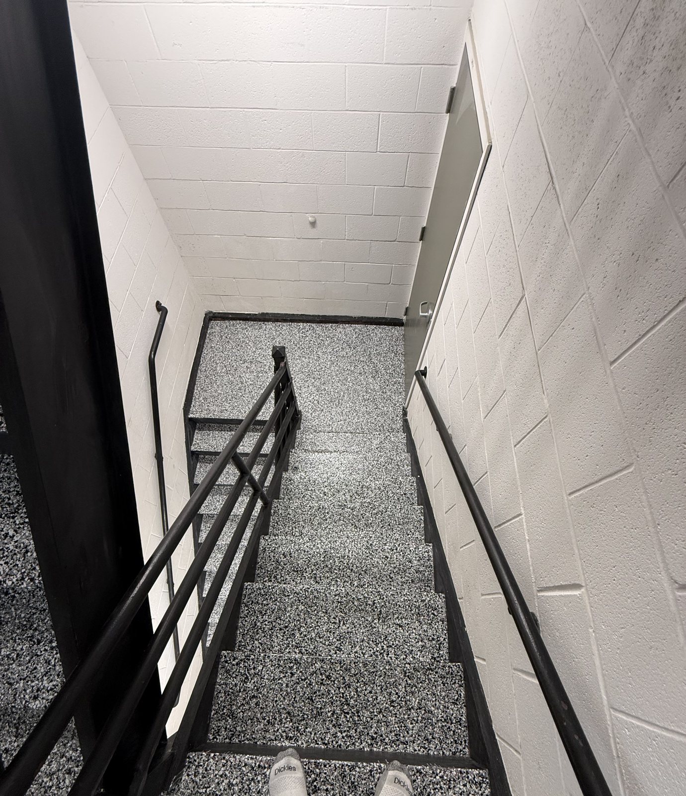 Grey flake epoxy staircase with a metal handrail