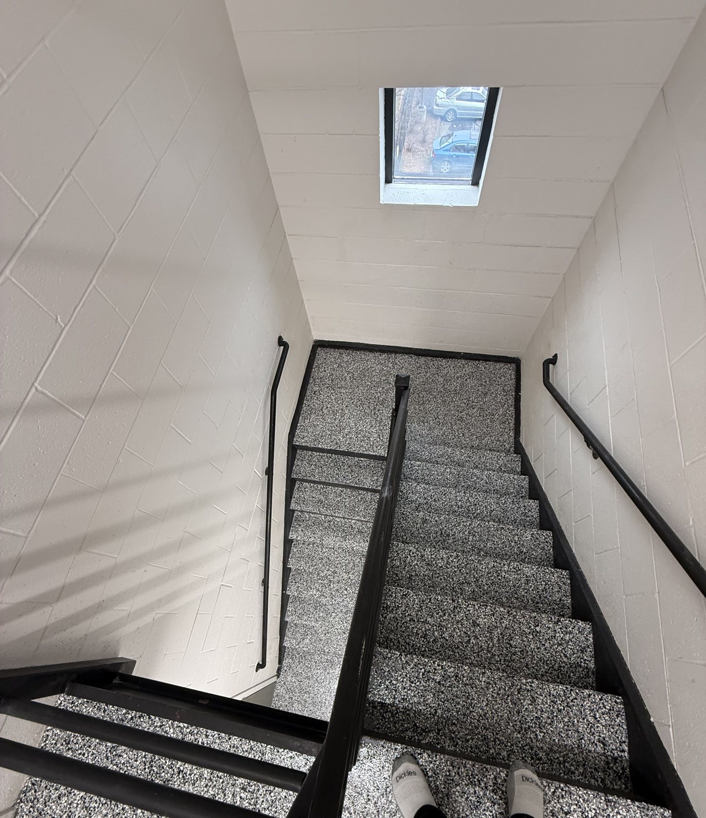 Grey flake epoxy coating on a commercial staircase, looking down the stairs