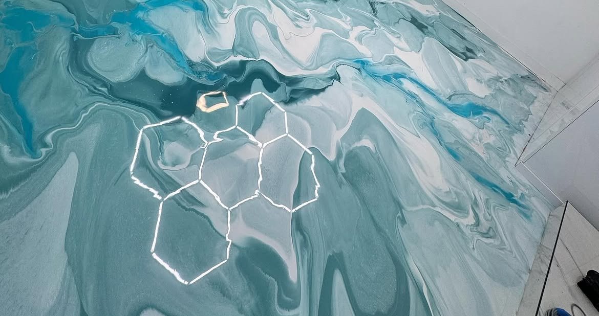 Teal and white metallic epoxy garage floor with hex-light reflection