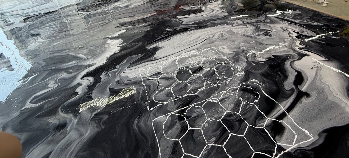 Black and white metallic epoxy floor with a white honeycomb vein pattern
