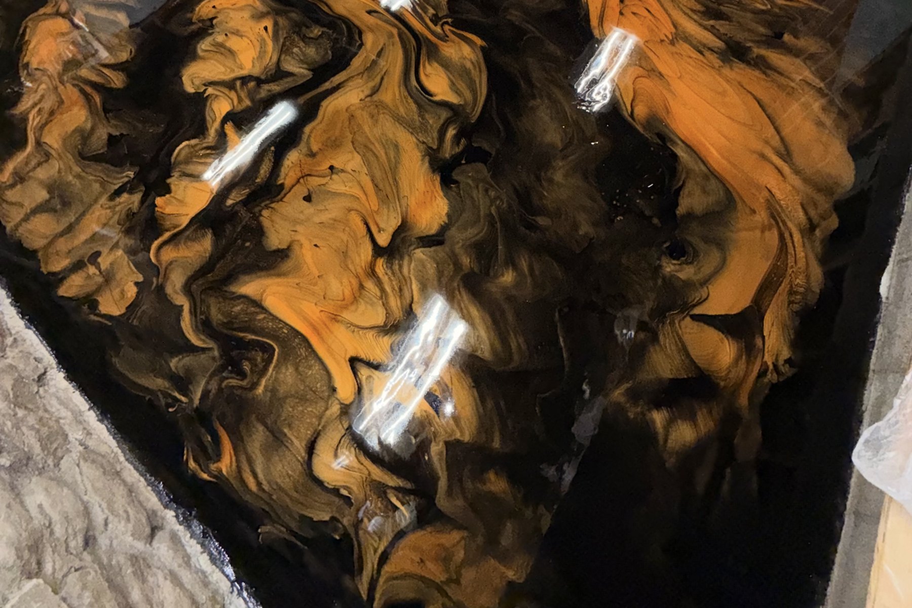 Orange and black metallic epoxy garage floor with a mirror gloss
