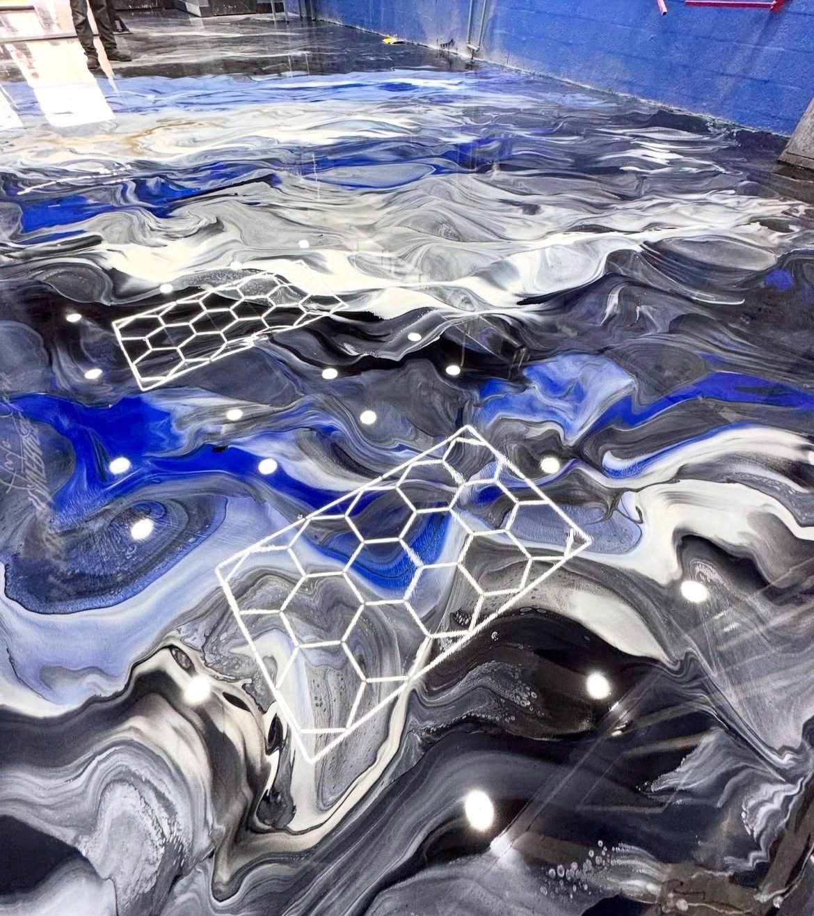 Blue and white metallic epoxy floor with hex-light reflection