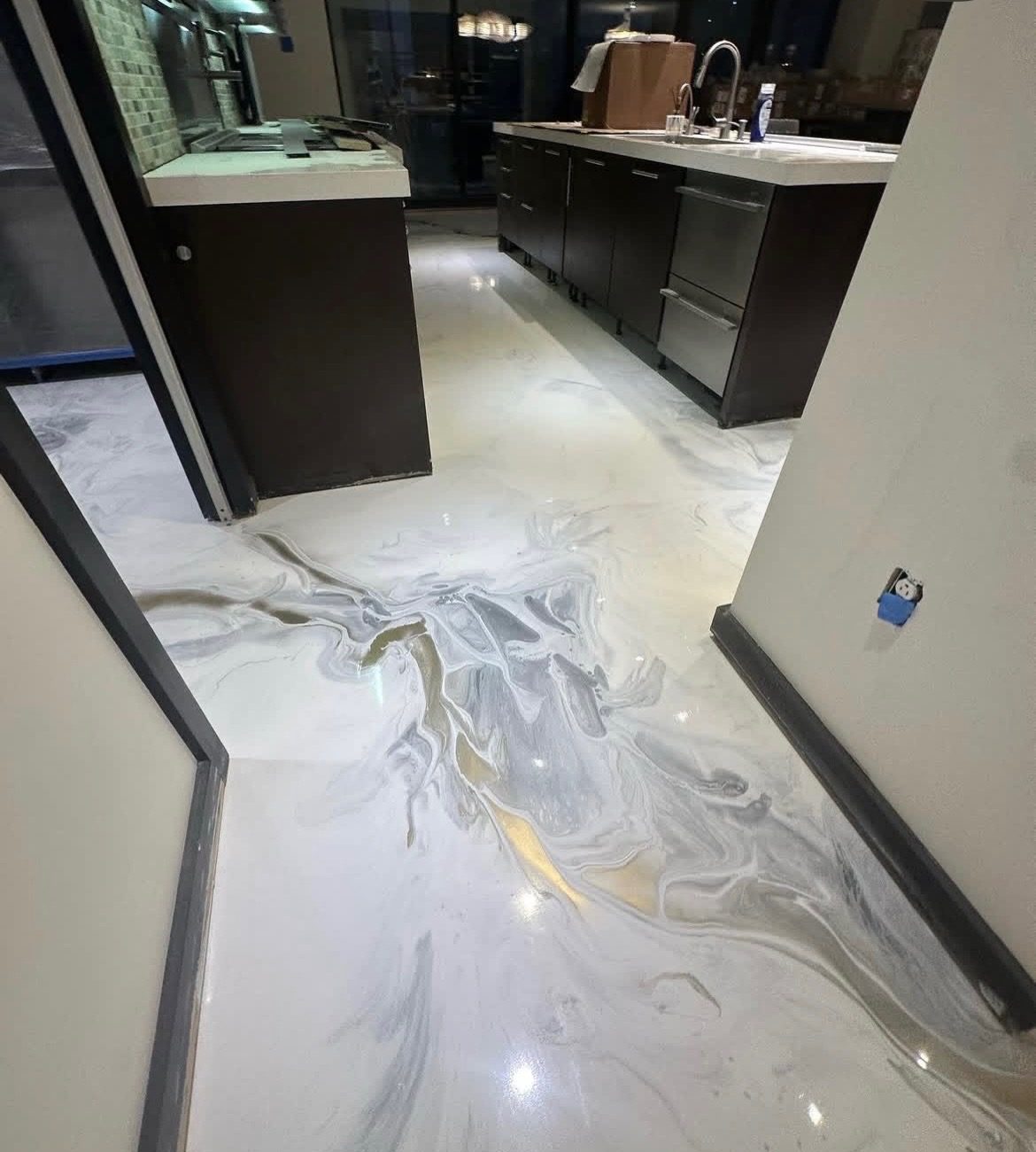 Metallic epoxy floor in a kitchen with dark cabinets