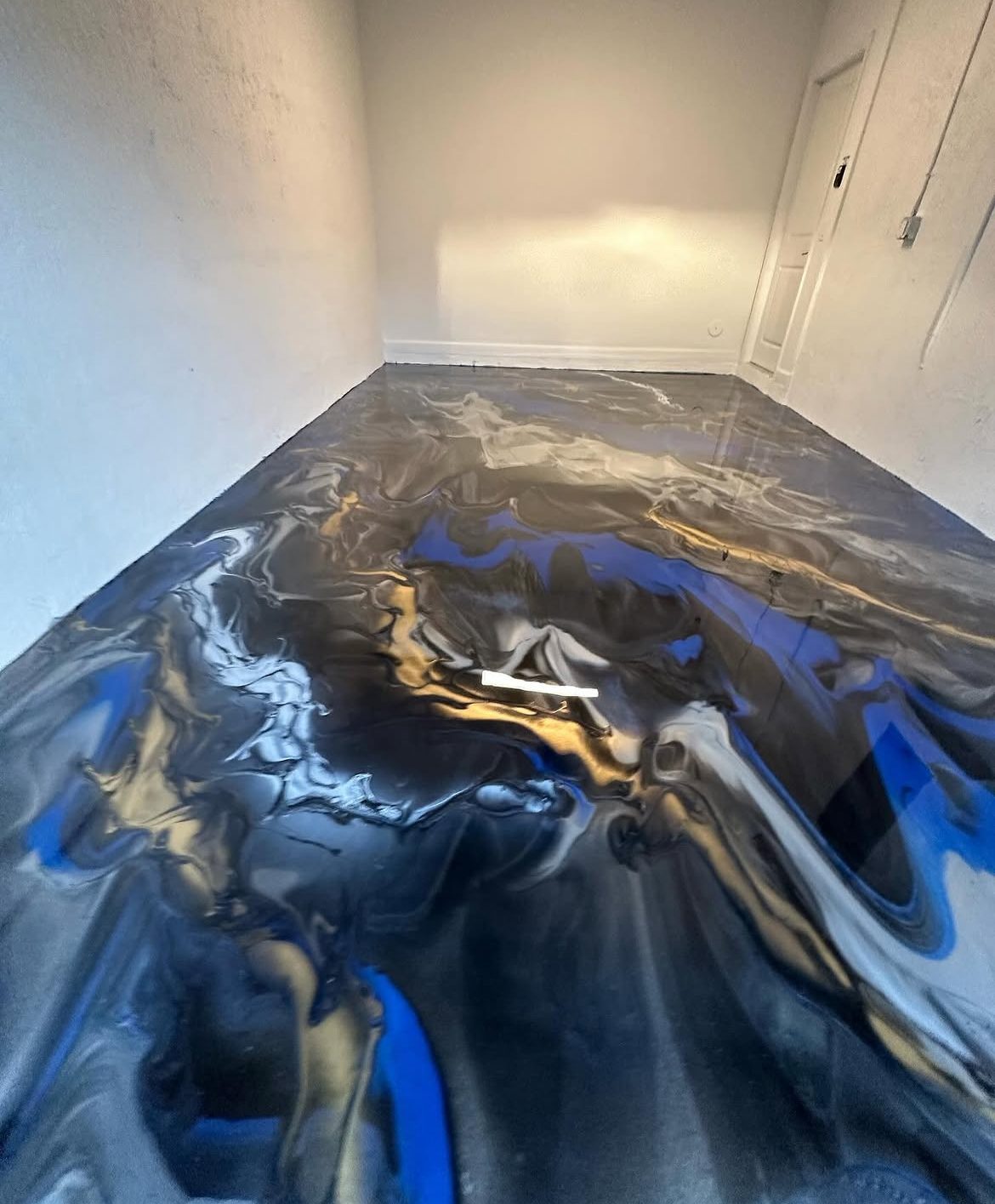 Blue and gold metallic epoxy floor with an ocean-like swirl