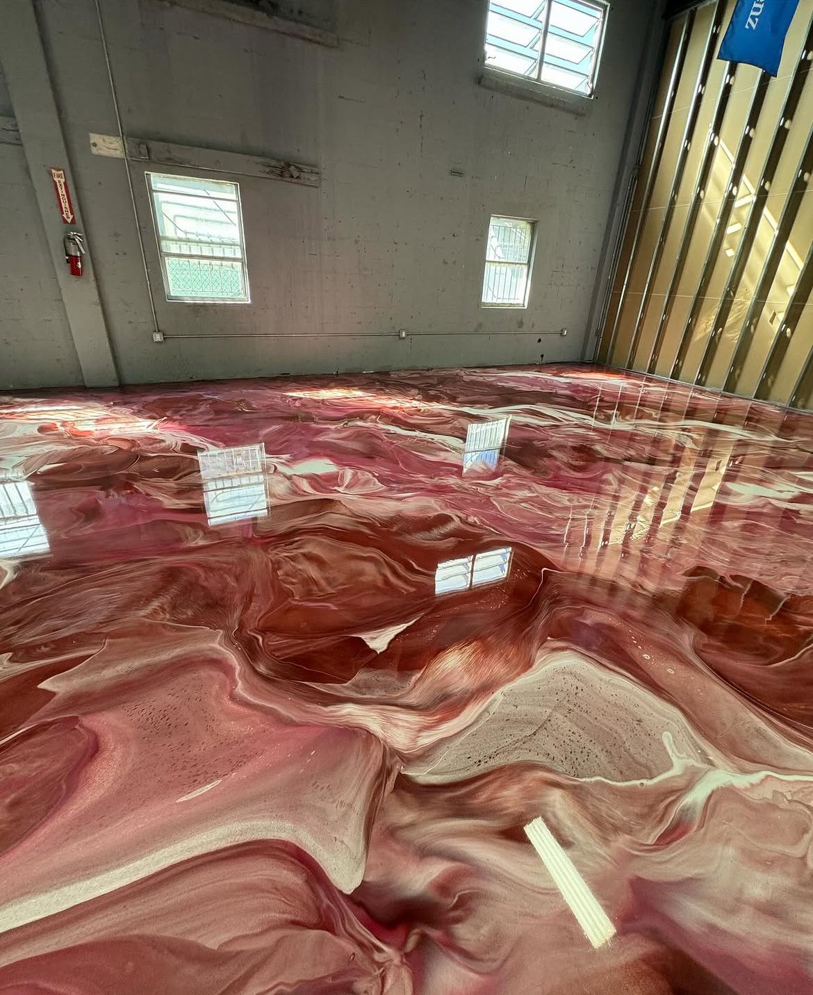 Crimson and copper metallic epoxy floor across a warehouse
