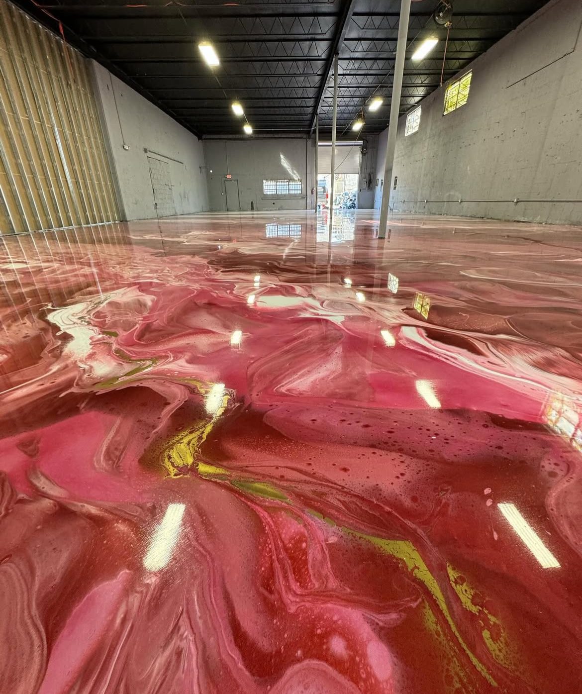 Crimson metallic warehouse floor under working lighting