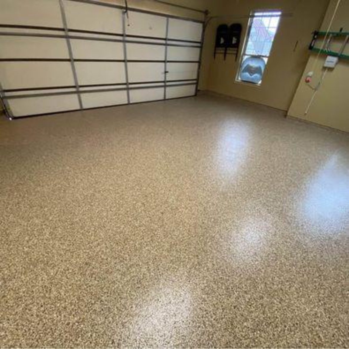 Tan quartz broadcast epoxy floor in a garage
